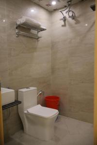 a bathroom with a toilet and a sink at SS Residency in Gorakhpur +4 photos