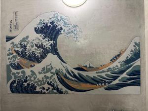 a painting of a wave in a room at 姫路城下町 巡 in Himeji