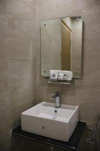 a bathroom with a white sink and a mirror at SS Residency in Gorakhpur
