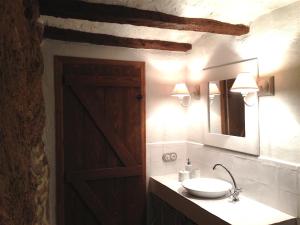 baño con lavabo, espejo y puerta en El Encanto de Mora, en Mora de Rubielos