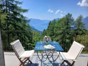 a table and two chairs on a balcony with mountains at il larice d' oro in Sueglio