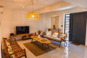 a living room with a couch and a table at Les Clos de L Albatros in Saint-Paul