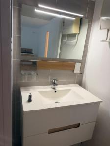 a bathroom with a white sink and a mirror at Studio avec terrasse et parking privé in Château-Arnoux-Saint-Auban