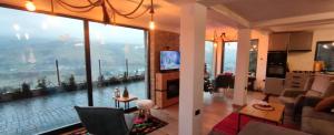 a living room and a kitchen with a large window at Loft Bucovina in Gura Humorului