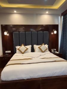 a bedroom with a large bed with a black headboard at The Grand K2 Hotel in Leh