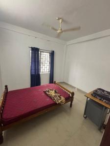 a bedroom with a bed and a window at Kuttikkanam stay in Pīrmed