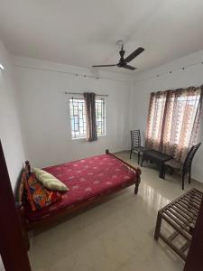 a bedroom with a red bed and two windows at Kuttikkanam stay in Pīrmed