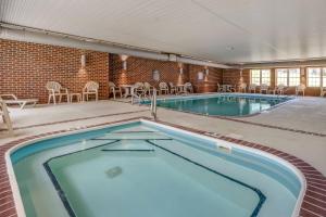 a large swimming pool with chairs and tables at Comfort Suites Hotel and Conference Center in Berlin