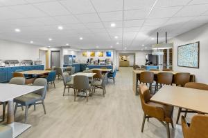 a dining room with tables and chairs and a cafeteria at Comfort Suites Hotel and Conference Center in Berlin