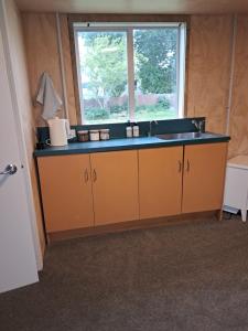 a kitchen with a sink and a window at The Big Chook Accommodation in Waianakarua +8 photos