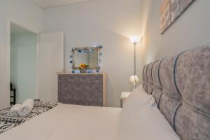 a bedroom with a white bed and a mirror at Comfy Apt next to metro in Athens