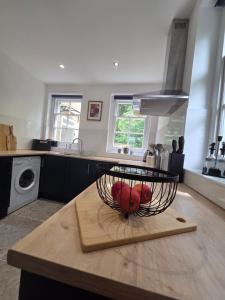 a kitchen with a bowl of fruit on a table at St Marys Cottage 2 in Dover