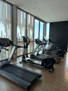 a row of tread machines in a gym with windows at Tunjong Stay in Kota Bharu