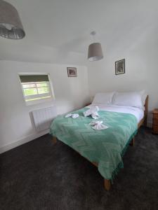a bedroom with a bed with a green blanket at St Marys Cottage 2 in Dover