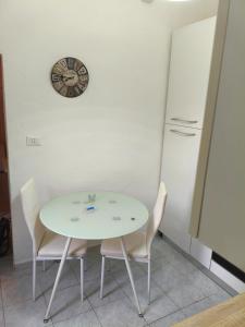 a table and chairs in a kitchen with a clock on the wall at oasi di Villa Erbosa in Bologna