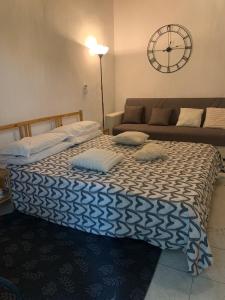 a bed in a room with a couch and a clock at oasi di Villa Erbosa in Bologna