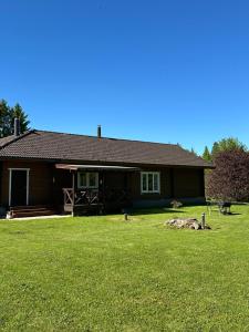 a house with a green lawn in front of it at Pihlamäe holiday house in Aruvalla