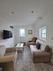 a living room with two couches and a flat screen tv at St Marys Cottage 2 in Dover