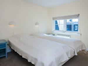 a white bedroom with a bed and a window at 4 star holiday home in Ringkøbing in Ringkøbing