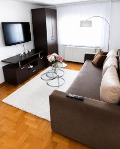 a living room with a couch and a flat screen tv at Apartman Layla in Bihać
