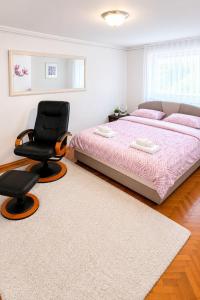 a bedroom with a bed and a black chair at Apartman Layla in Bihać +15 photos