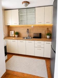 a kitchen with white cabinets and a sink at Apartman Layla in Bihać