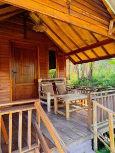 a porch of a cabin with a bench and a door at Bintang Homestay in Tetebatu