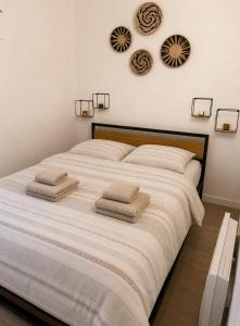 a bedroom with a large bed with towels on it at Le Cosy - T4 avec terrasse privée, Face à la mer avec parking et wifi in Sète +13 photos