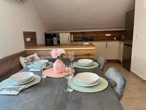 a dining room table with plates and wine glasses at Apartma Tri Planike in Mojstrana