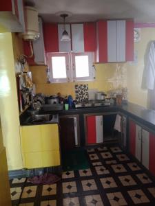 a small kitchen with red white and yellow cabinets at Karnai Residency in Srinagar