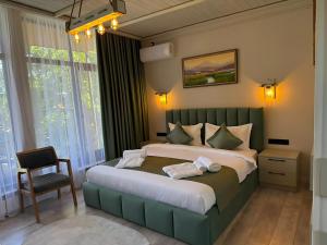 a bedroom with a large bed and a chair at Kausar Hotel in Bishkek