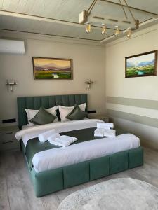a bedroom with a large green bed in a room at Kausar Hotel in Bishkek