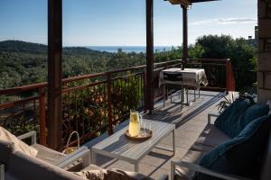 a patio with a table and chairs on a balcony at House Demetra in Astris