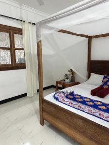 a bedroom with a bed with a canopy at Kipe House Nungwi in Nungwi