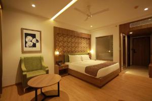 a bedroom with a bed and a table and a chair at MANDARIN SKY in Kannur +19 photos