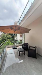 a patio with a table and a large umbrella at Nâu Homestay in Hai Phong