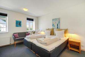 a bedroom with a large bed and a chair at Skjoldbjerg Garnihotel in Vorbasse