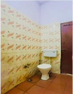 a bathroom with a toilet and a wall with fish patterns at Hotel cozy guest house in Alīgarh