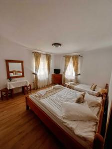a bedroom with two beds and a desk and a sink at Popasul Craiului in Zărneşti +25 photos