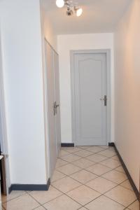 a hallway with a white door and a tiled floor at La Forclaz in Annecy