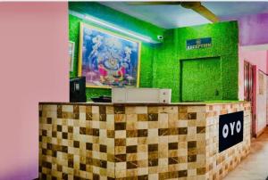 a room with a green wall with a checkerboard counter at Hotel cozy guest house in Alīgarh