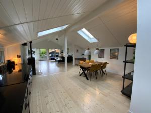 a dining room and living room with a table and chairs at Natur, fjord og hygge nær Roskilde in Kirke-Hyllinge
