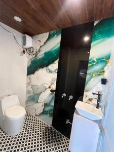 a bathroom with a white toilet and a sink at Hyton Grand - Kilambakkam in Urapakkam