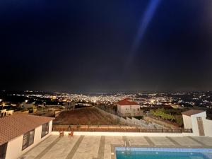 a view of a city at night from a building at ڤيلا الكرم in Jerash