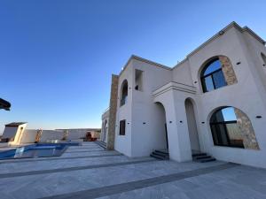 a large white house with a swimming pool at ڤيلا الكرم in Jerash