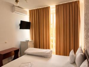 a hotel room with a bed and a window at Pensiunea Rozeclas in Sînmartin