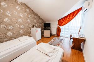 a living room with two beds and a kitchen at Pensiunea Rozeclas in Sînmartin
