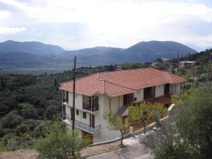 una casa con techo rojo en una colina en San Pedro, en Vasiliki