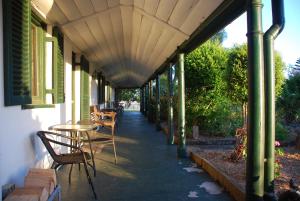 a covered walkway with chairs and tables on a building at Lochinvar House in Lochinvar