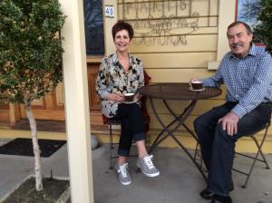 a man and a woman sitting at a table with cups of coffee at Villa Rouge B&B in Invercargill